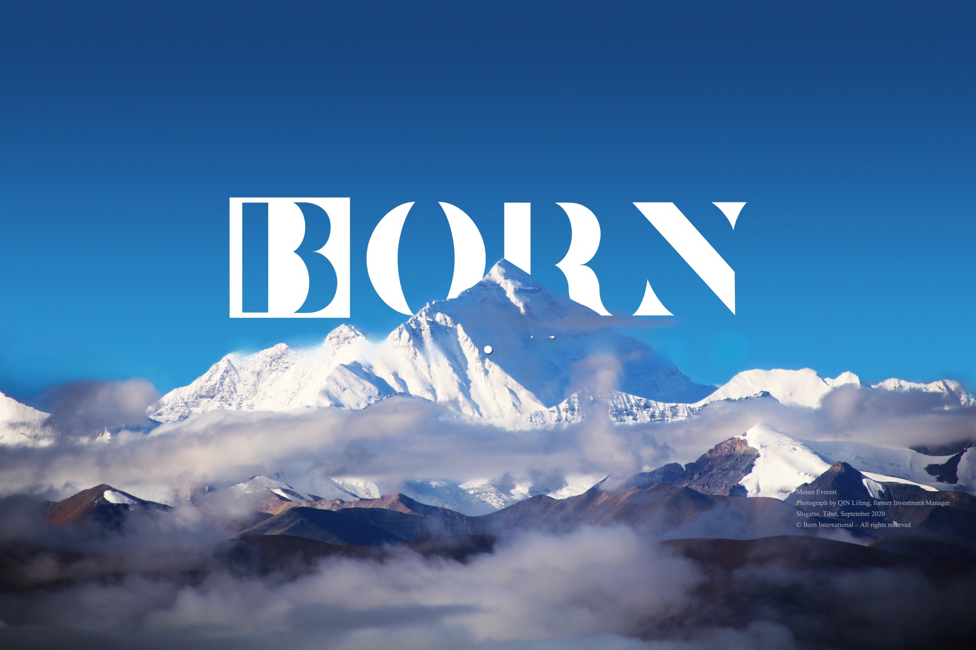 BORN Capital mountain landscape with snow-capped peaks and blue sky